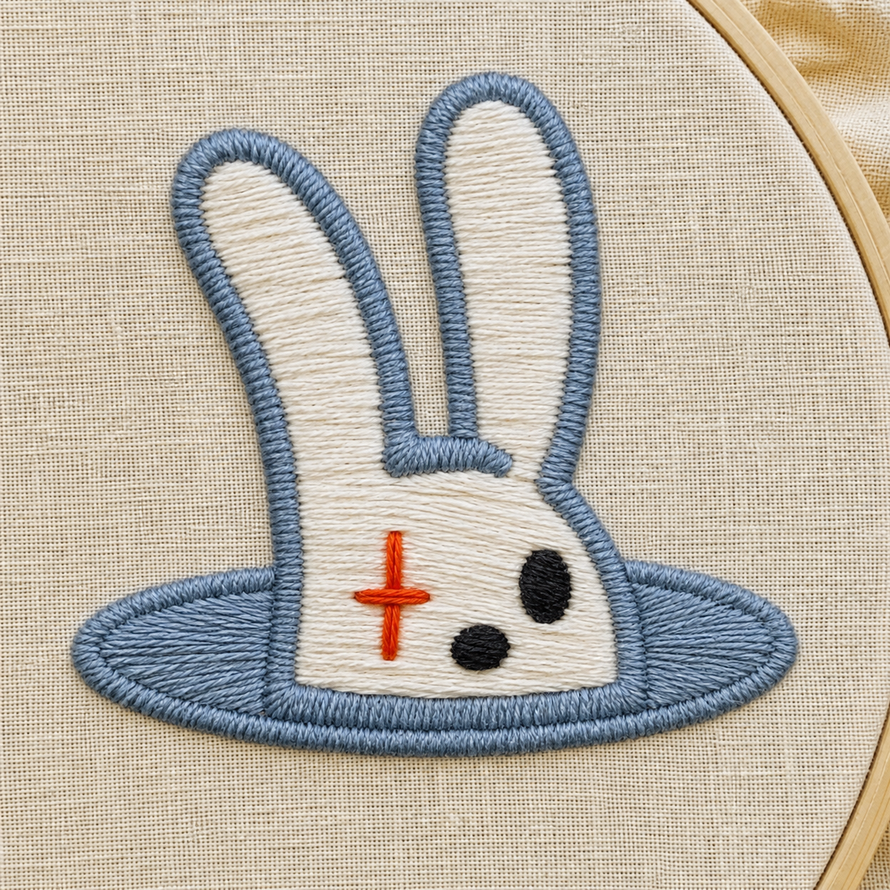 Illustrative close-up of the Tofu bunny mark embroidered in blue, orange and black thread